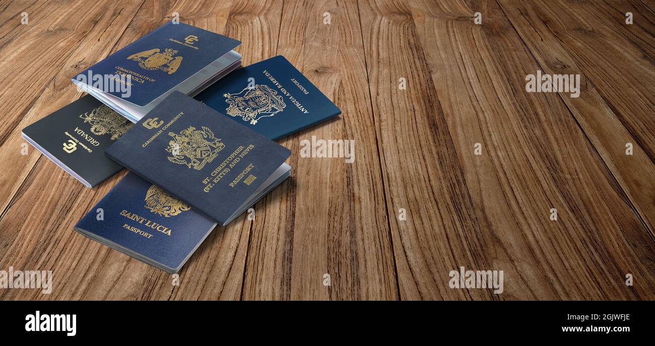 Caribbean passports, Dominica, Saint Kitts and Nevis, Grenada, Saint Lucia, Antigua and Barbuda on wooden background Stock Photo