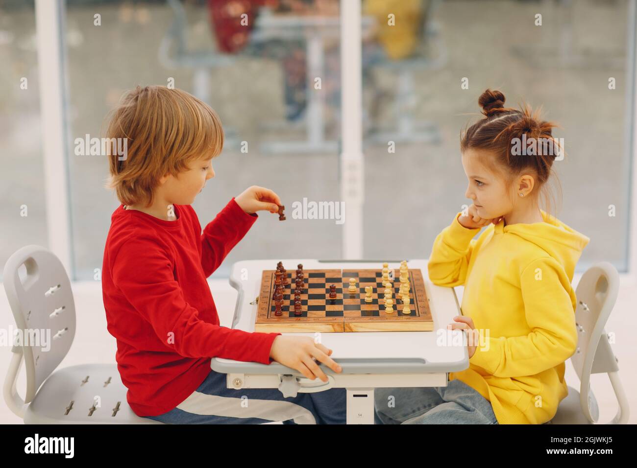 Little kids playing chess at kindergarten or elementary school. Children's chess play Stock Photo