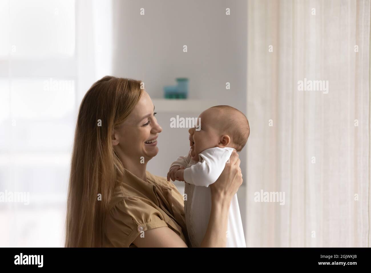 Happy mom holding adorable baby in arms Stock Photo
