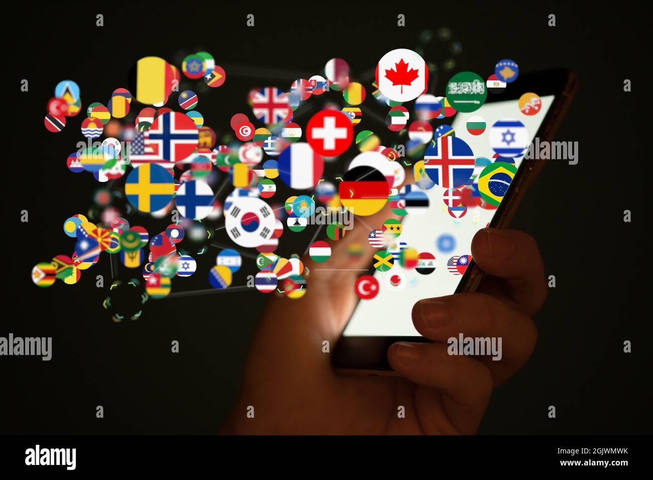 A closeup shot of digital country flags coming out the white smartphone ...