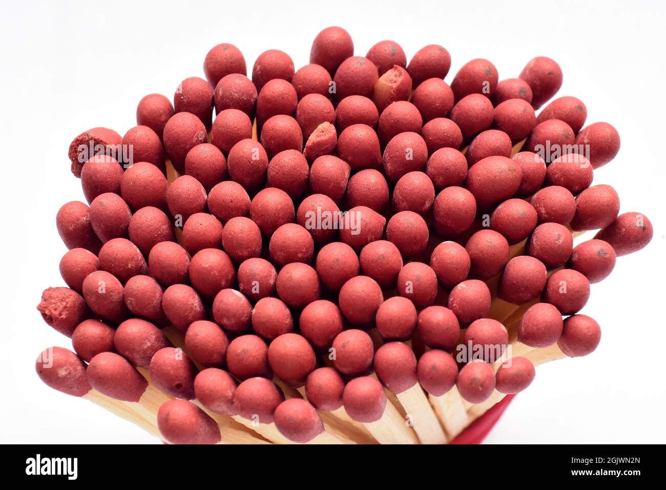 close up macro of red matchstick heads against white background Stock Photo