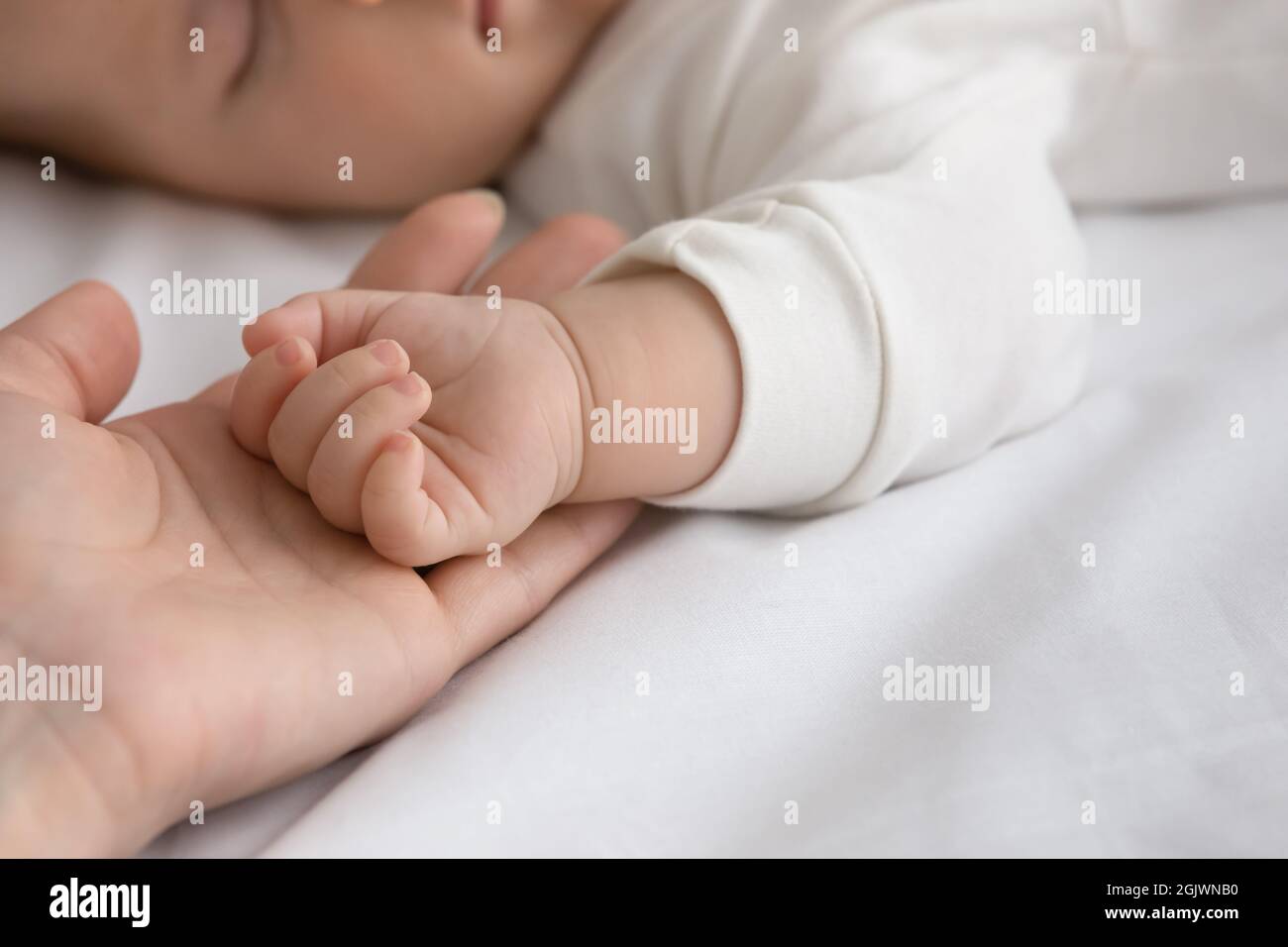 New mom and newborn baby hands close up Stock Photo