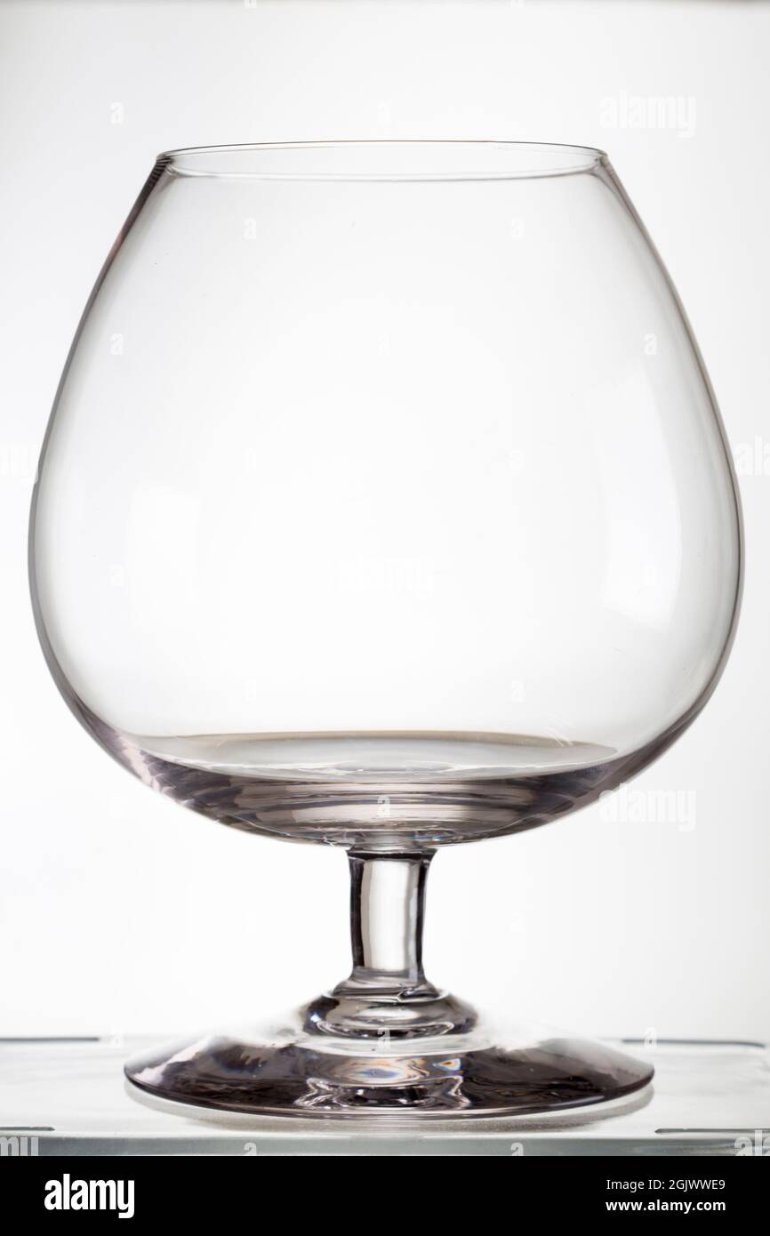 view of a glass of liquor, brandy, cognac, balloon type, on a white