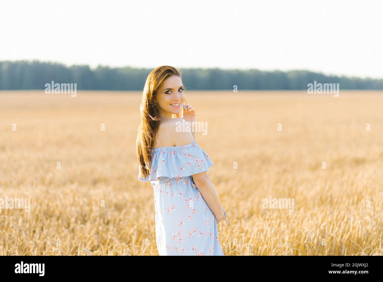 A high pregnant woman lifting up her dress and looking at her big