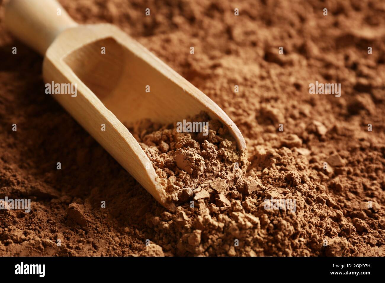 Wooden scoop on cocoa powder background Stock Photo - Alamy