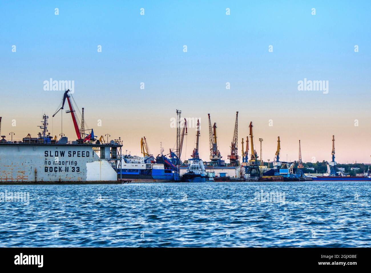 Sea port with working cranes & cargo ships Stock Photo