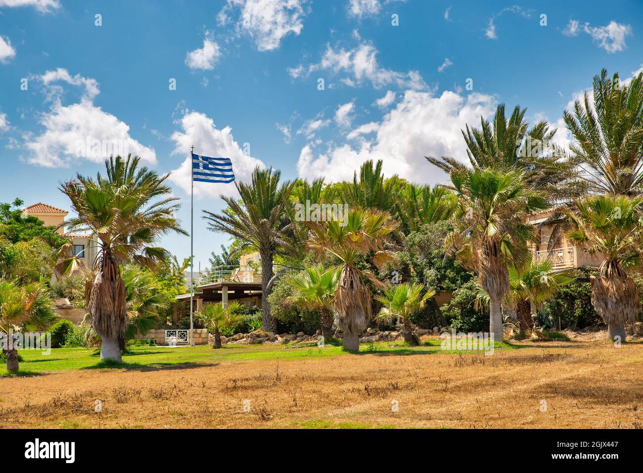 Landscape with typical Cypriot residential architecture and Greek national flag in Ayia Napa, Cyprus. Stock Photo