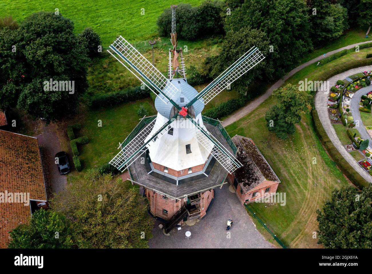 12 September 2021, Lower Saxony, Barßel: The Ebkenssche Windmühle, a three-storey gallery windmill from 1892, stands in the village in sunny weather (aerial view with drone). In addition to castles and museums in Lower Saxony, numerous historic mills also open their doors to visitors on Open Monument Day. Photo: Hauke-Christian Dittrich/dpa Stock Photo