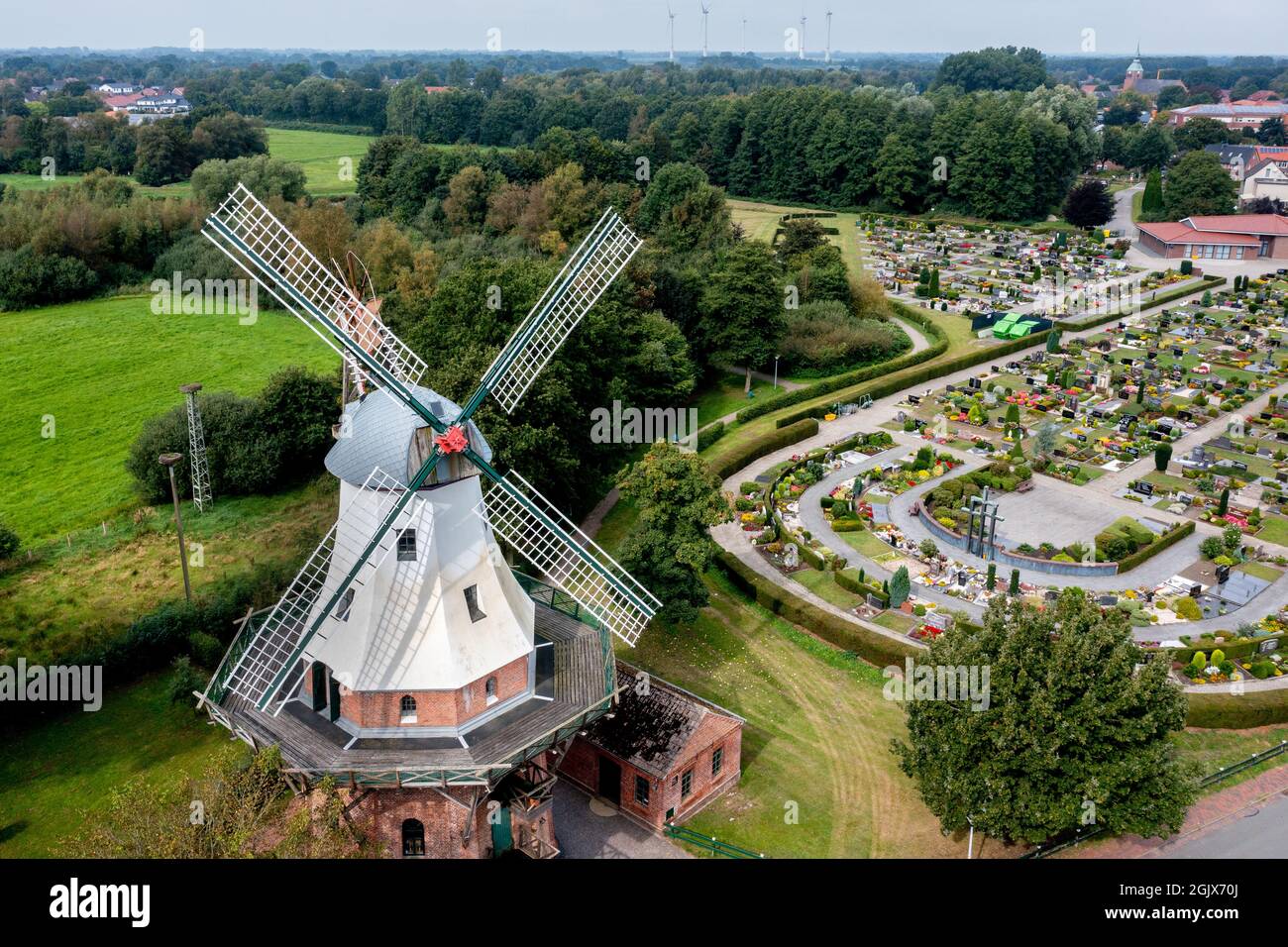 12 September 2021, Lower Saxony, Barßel: The Ebkenssche Windmühle, a three-storey gallery windmill from 1892, stands in sunny weather in the village in front of the cemetery (aerial view with drone). In addition to castles and museums in Lower Saxony, numerous historic windmills also open their doors to visitors on Open Monument Day. Photo: Hauke-Christian Dittrich/dpa Stock Photo
