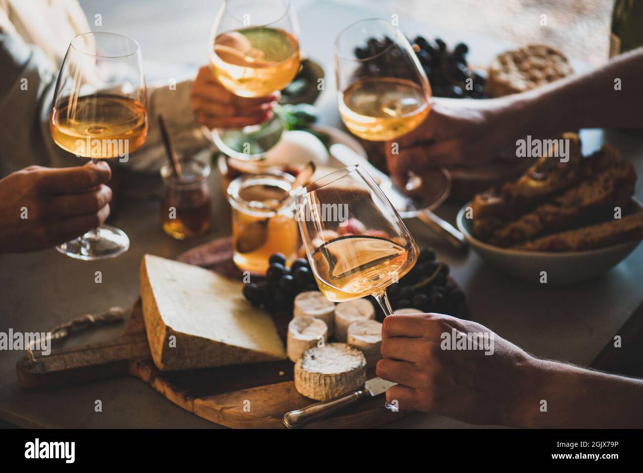 Hands of people holding wineglasses with orange or rose wine Stock Photo