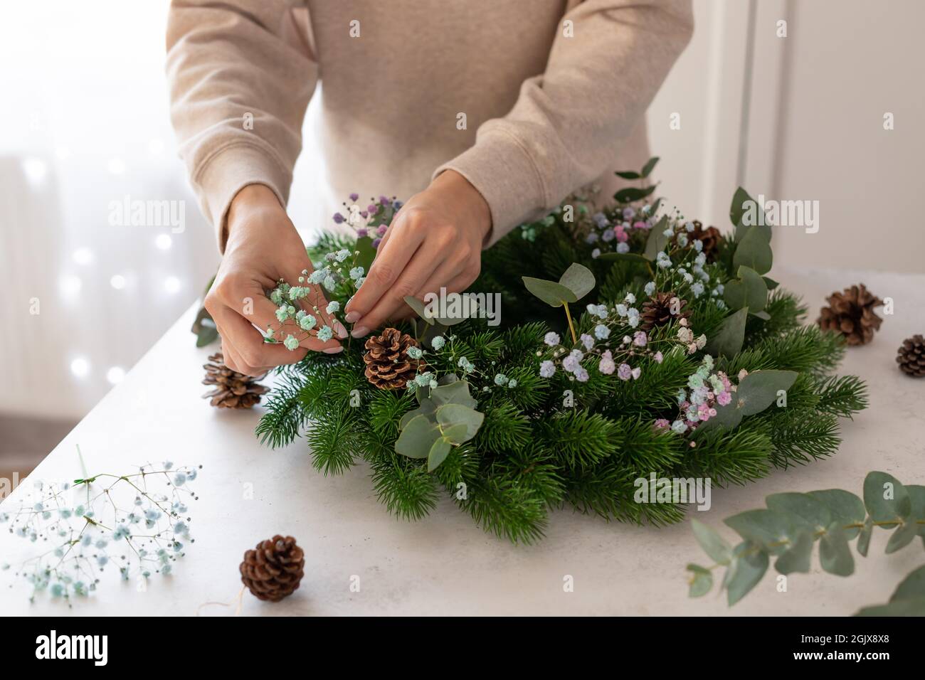 florist making Christmas wreath with gypsophila, eucalyptus Stock Photo