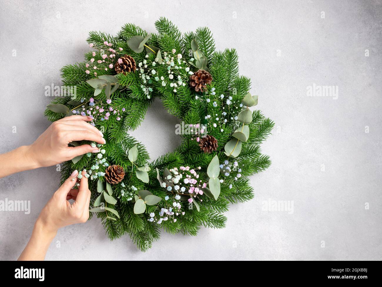 person hands making Christmas wreath. Christmas gift self made Stock Photo