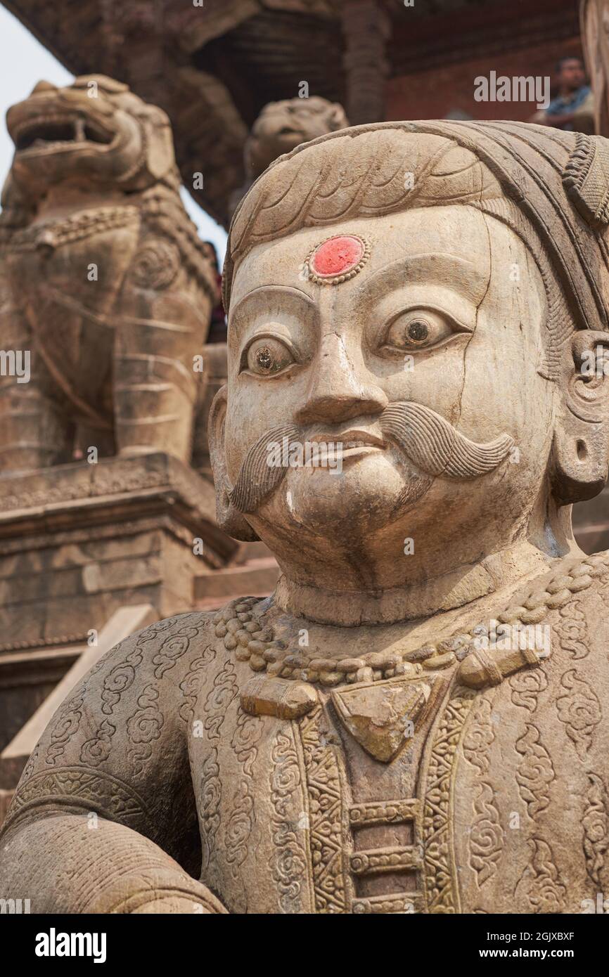 The head of a large Malla (wrestler) statue guarding the stairs leading up to Nyatapola Temple, Taumadhi Square, Bhaktapur, Kathmandu Valley, Nepal Stock Photo