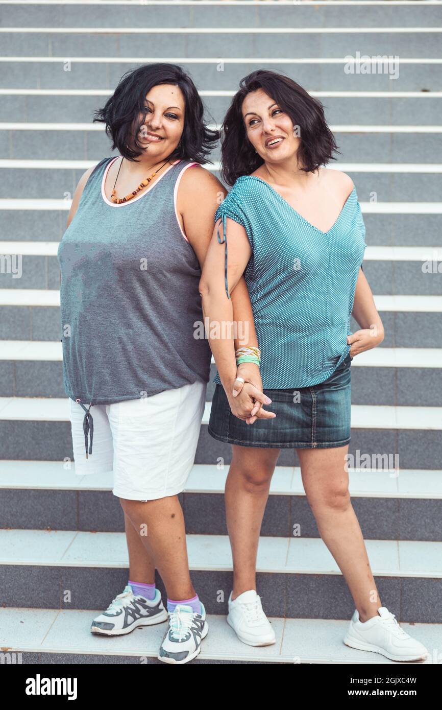 Portrait of two adult brunette twin sisters. Different styles Stock Photo