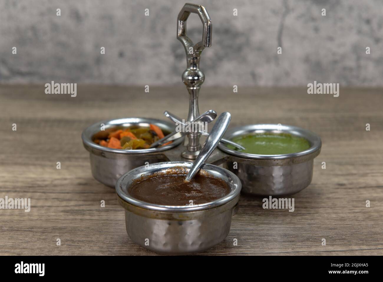 Flavor enhancing condiments with silver serving spoon and round cannisters for easy variety choice of seasoning for your food. Stock Photo