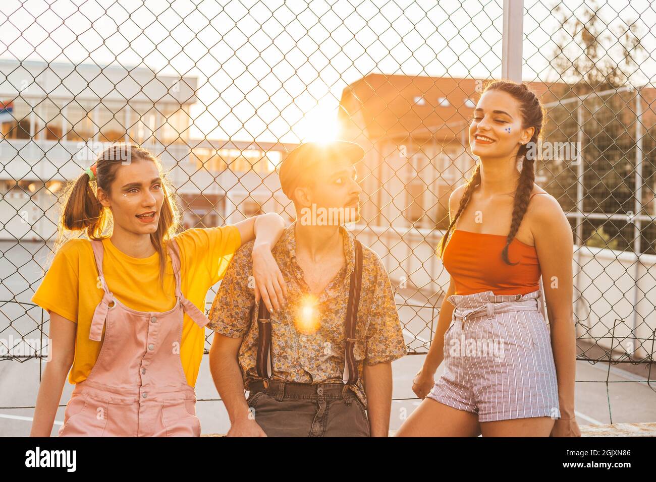 Group of teen friends hanging out together. Boy between two girls Stock Photo
