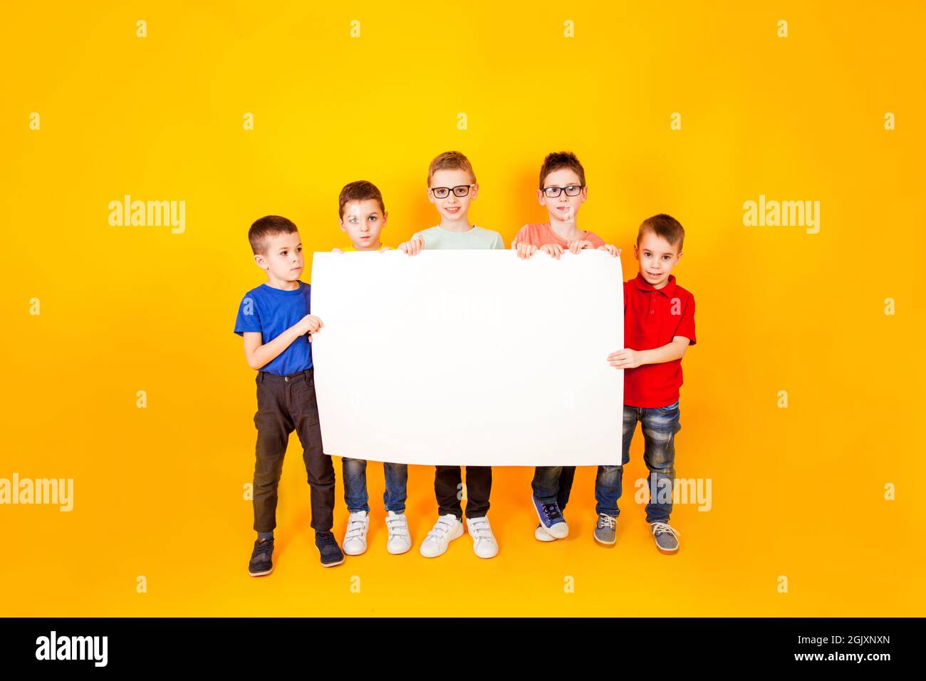 The different little boys are holding a big white paper Stock Photo - Alamy