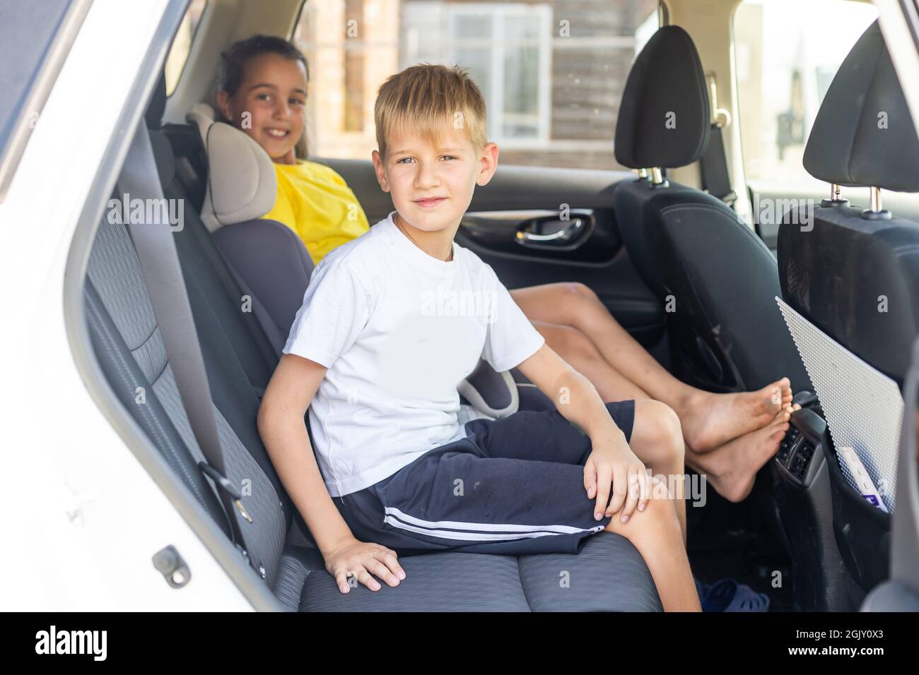 Smiling kids sitting on back seat of car Stock Photo - Alamy