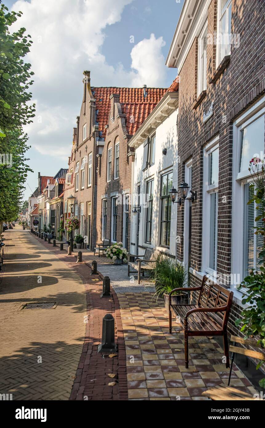 Hasselt, The Netherlands, August 11, 2021: slightly curved row of brick and plaster facades on Heerengracht canal in the old town Stock Photo