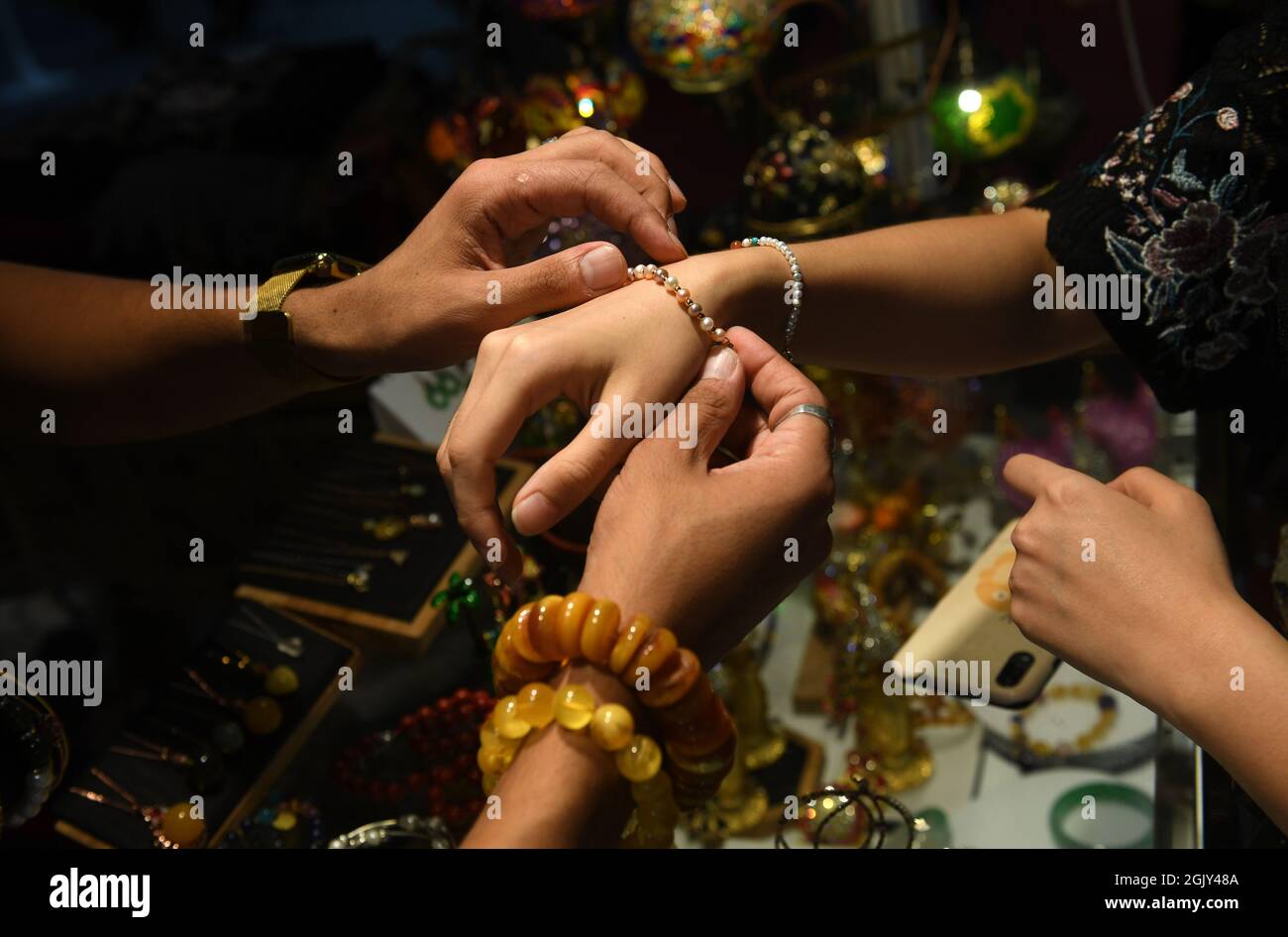 210912) -- NANNING, Sept. 12, 2021 (Xinhua) -- A visitor tries a bracelet  from Dubai during the 18th China-ASEAN Expo in Nanning, capital of south  China's Guangxi Zhuang Autonomous Region, Sept. 12,