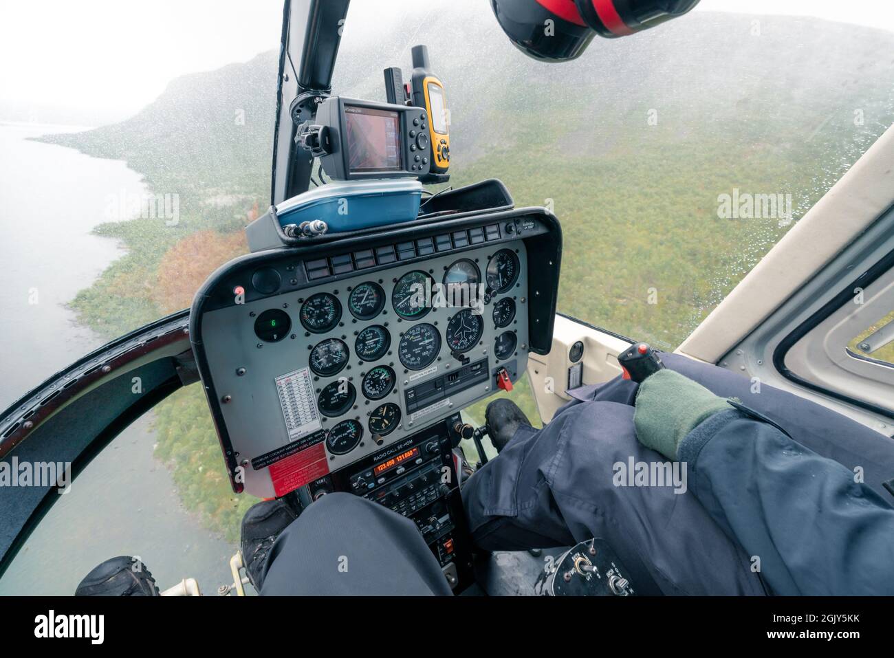Vietas, Sweden - 08.16.2021: Control panel in a cockpit of small helicopter with glass front and bottom flying over harsh arctic landscape on a very Stock Photo