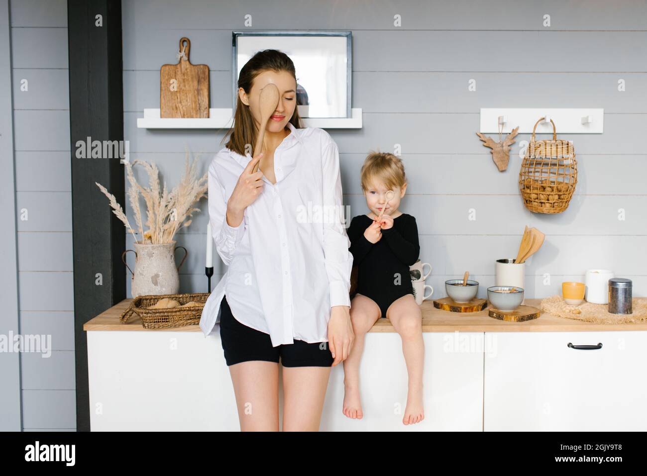 Mother and daughter have fun with wooden spoons Stock Photo