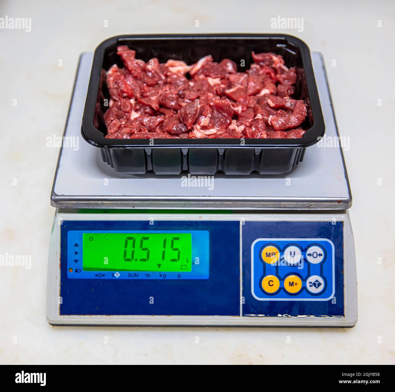 Fresh raw diced red beef meat (chopped in cubes) in a styrofoam container  with copy space for text. Weighing diced meat on scales Stock Photo - Alamy