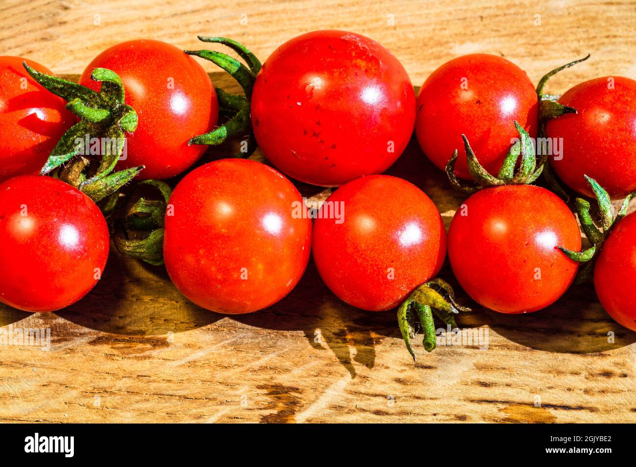 Fresh cherry tomatoes on rustic wooden background Stock Photo - Alamy