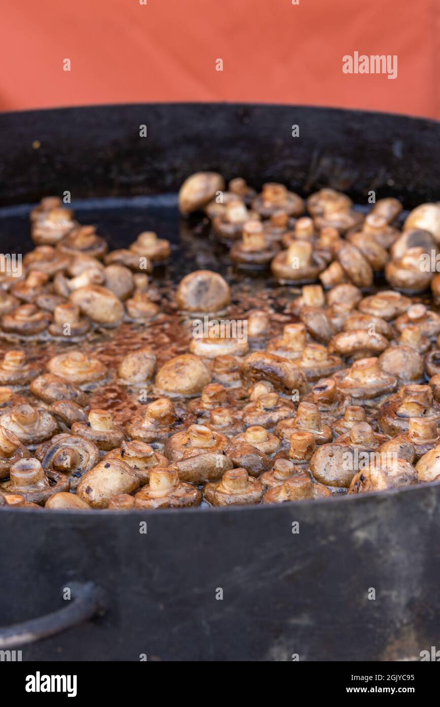 https://c8.alamy.com/comp/2GJYC95/large-frying-pan-with-fried-mushrooms-grilled-champignons-outdoors-street-food-2GJYC95.jpg