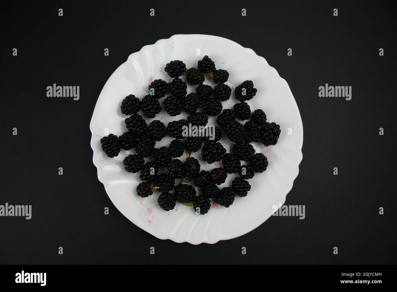 Nahaufnahme weißer Teller mit Bio Obst Brombeeren Stock Photo