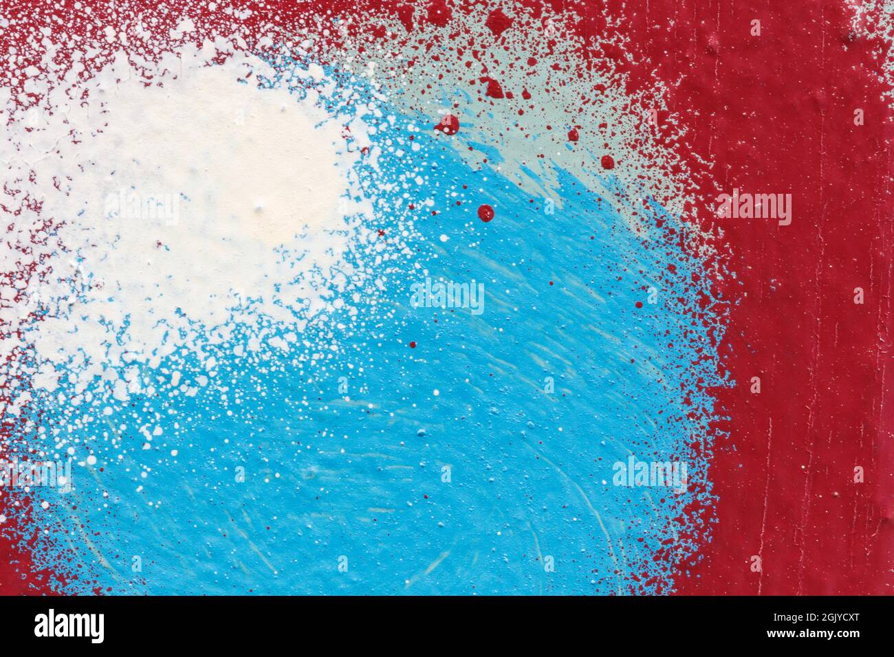 Macro close-up of white, blue and red spray paint with splashes. Abstract full frame textured splattered graffiti background with copy space. Stock Photo