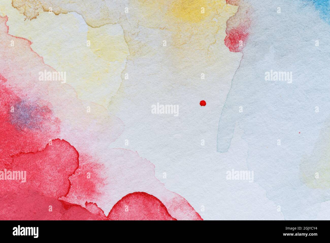 Macro close-up of an abstract red and yellow watercolor gradient fill background with watercolour stains. Full frame textured white paper background. Stock Photo