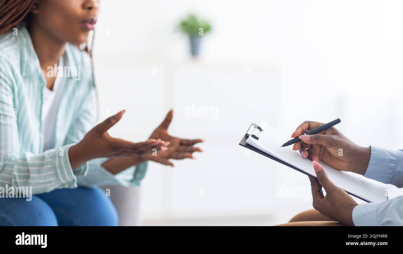 Psychologist providing professional psychological help to black female patient at clinic, closeup Stock Photo