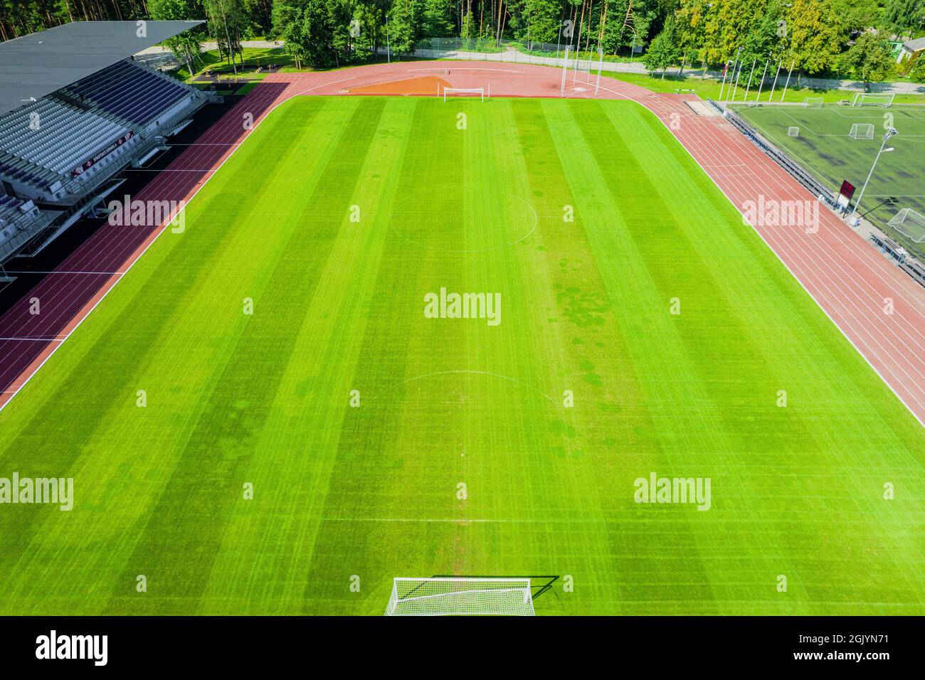 Aerial view of green football field. New public soccer stadium empty to be used for soccer game outdoors from above. Beautiful soccer playground as background texture concept Stock Photo