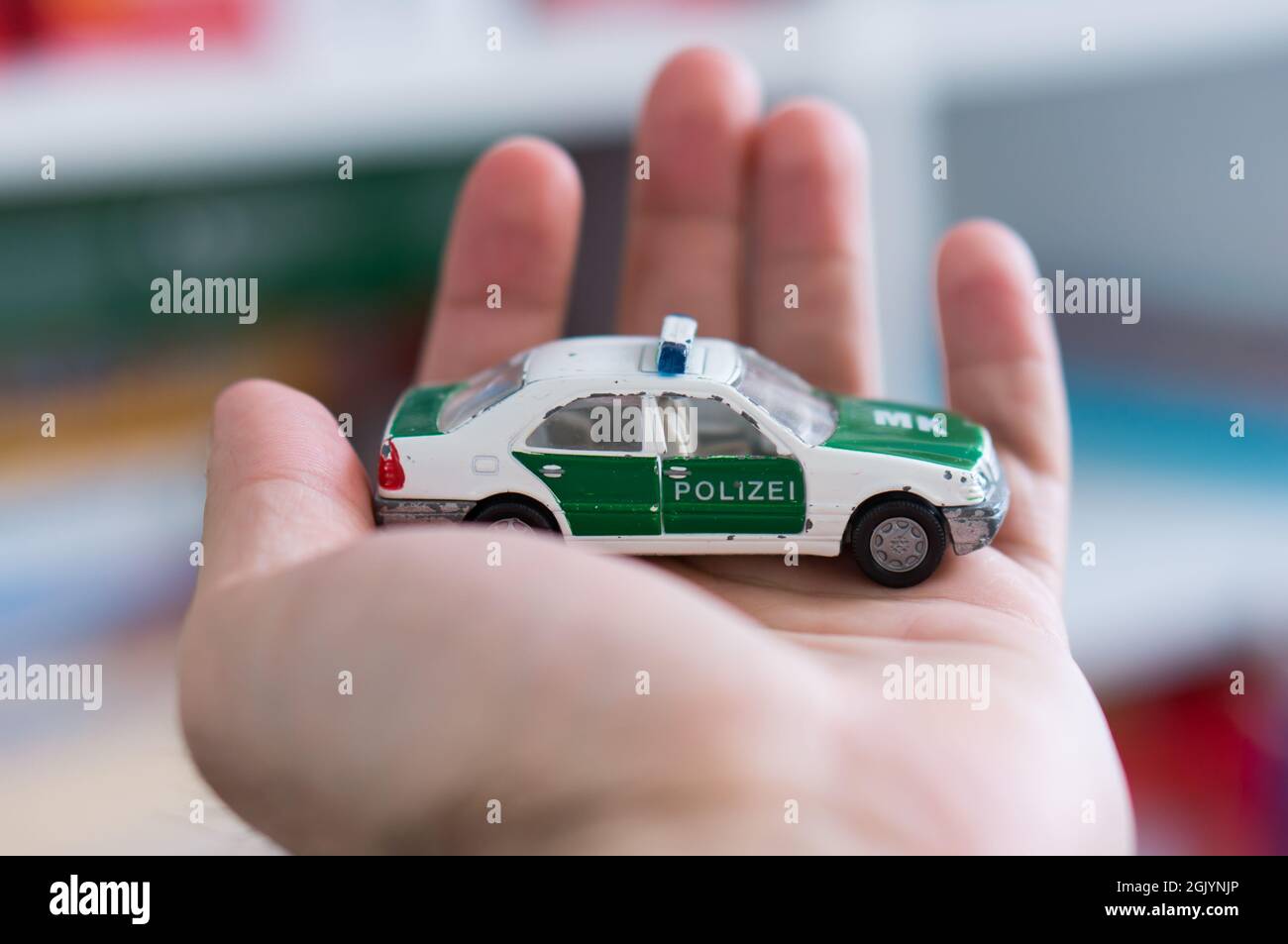 POZNAN, POLAND - Mar 25, 2018: A Siku brand toy German police car on an open hand in soft focus Stock Photo