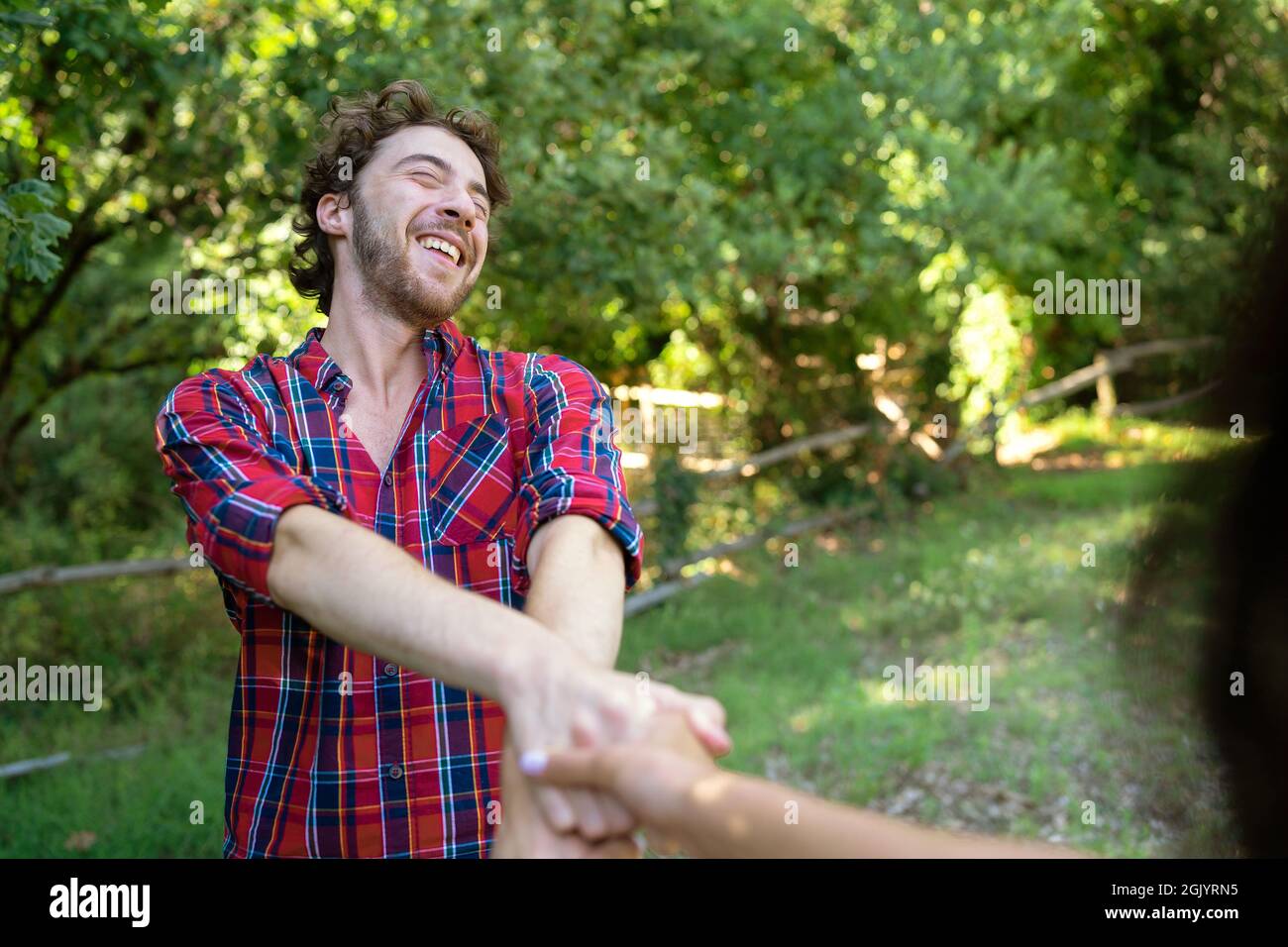 Happy boyfriend and girlfriend spinning together holding hands having ...