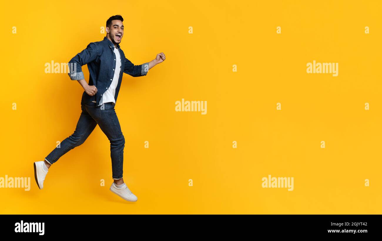 Excited arab guy running toward copy space Stock Photo