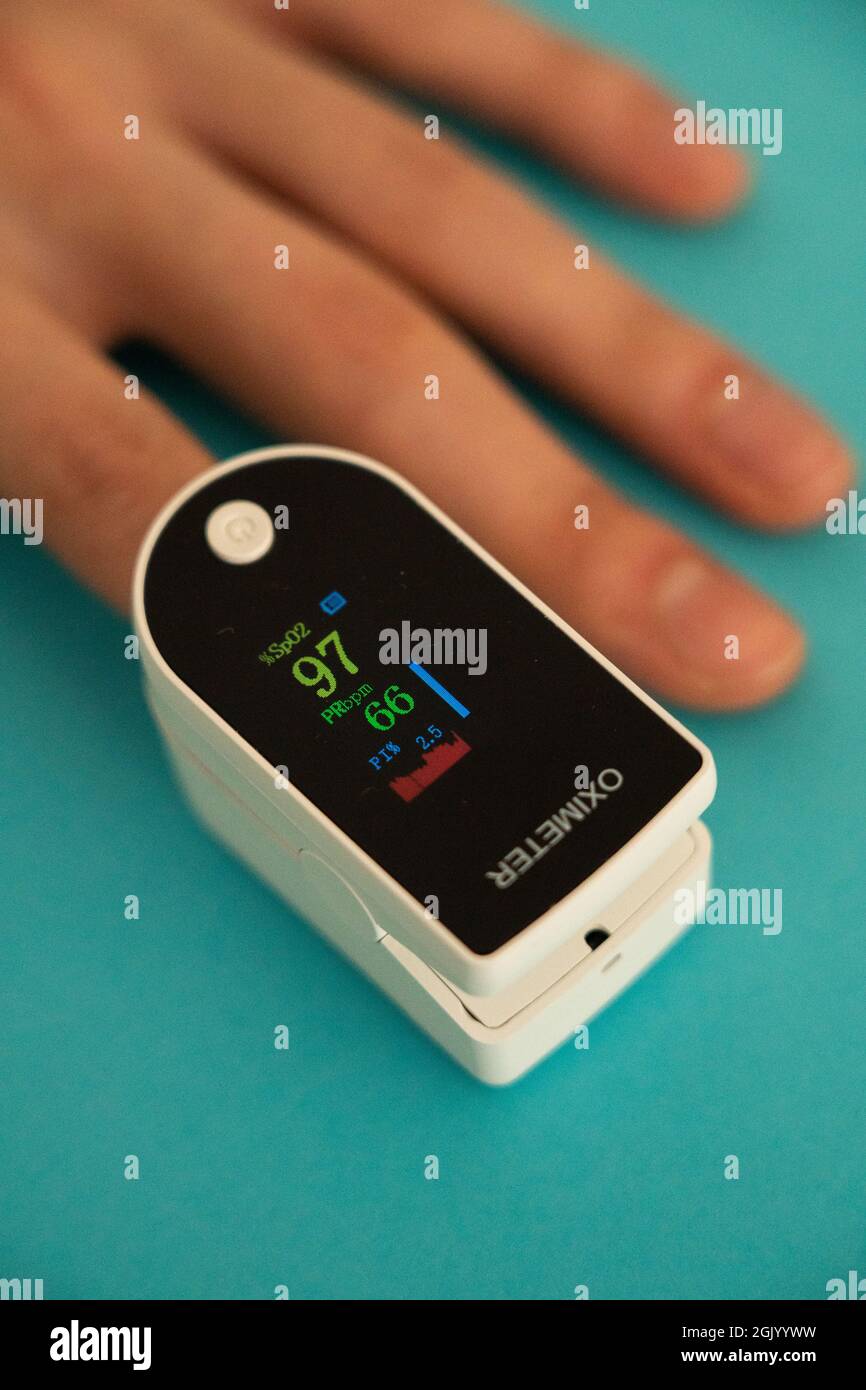 Person measuring their oxygen level using an oximeter Stock Photo Alamy