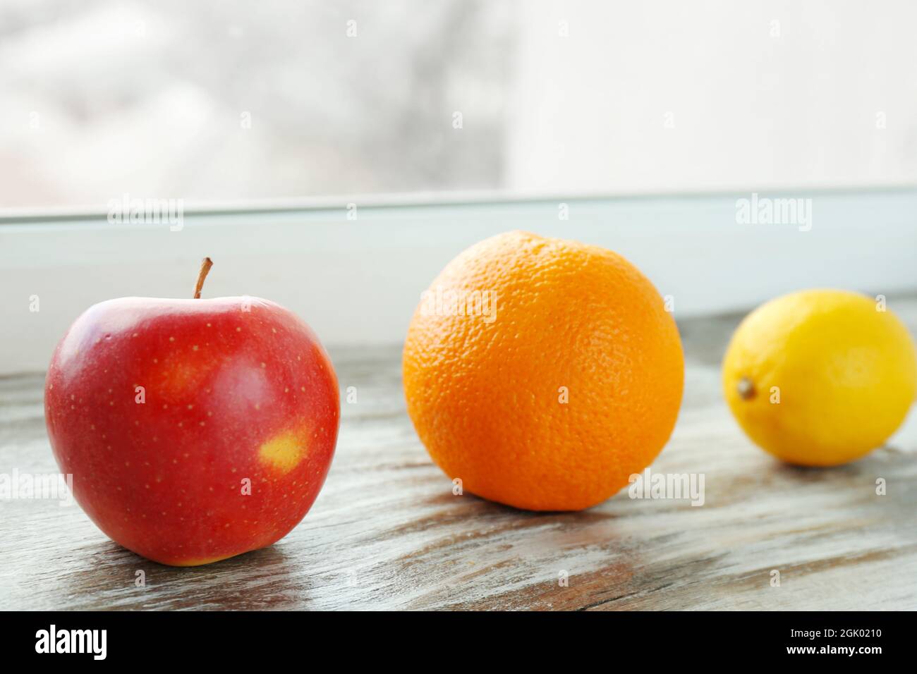 Apple, orange and lemon on windowsill Stock Photo Alamy