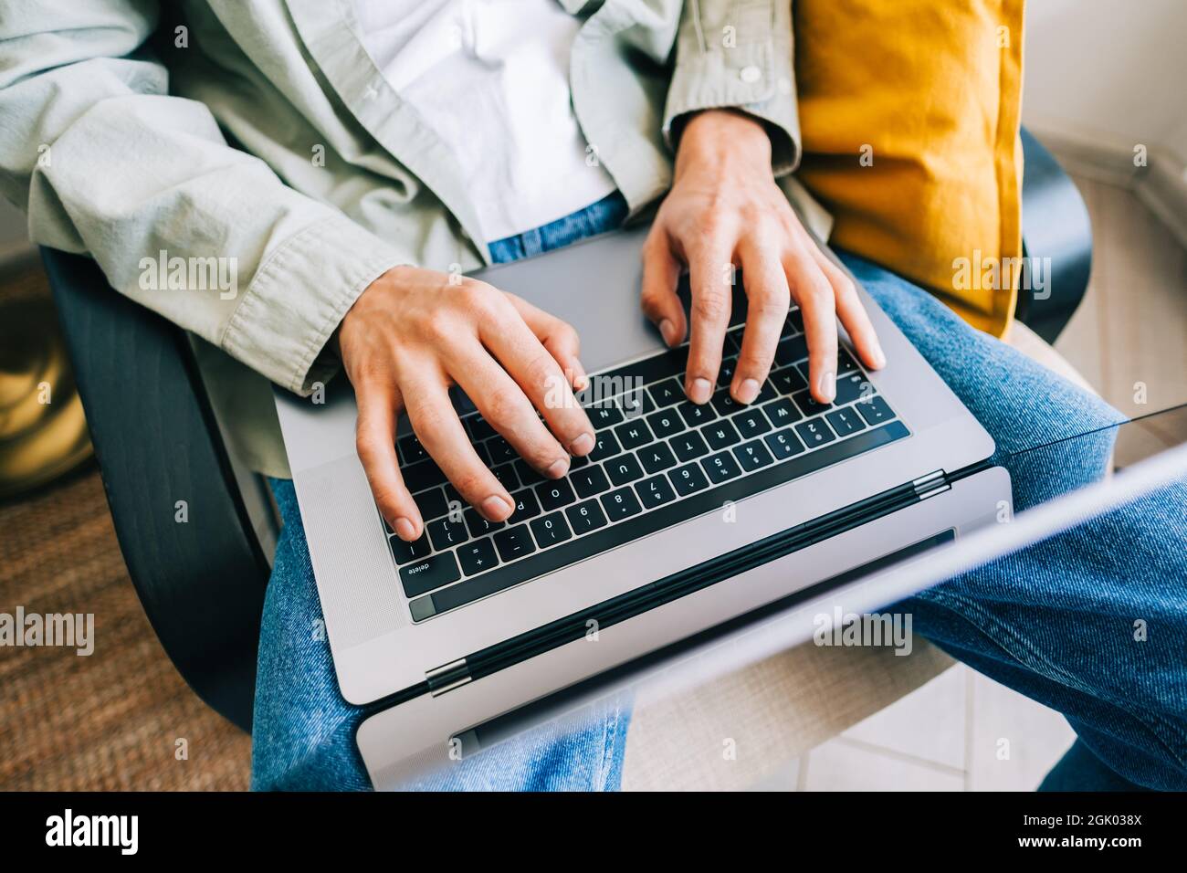 Young man mobile developer, programmer writes program code on a laptop computer in home office. Stock Photo