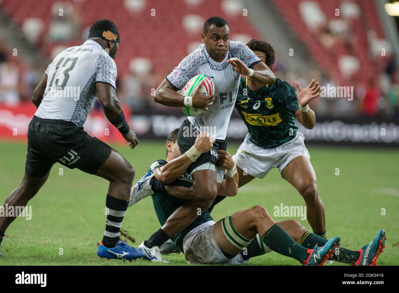 SINGAPORE-APRIL 14: Fiji 7s Team (white plays against South African 7s team (green) during the Cup Final match of HSBC World Rugby Singapore Sevens on April 14, 2019 at National Stadium in Singapore Stock Photo