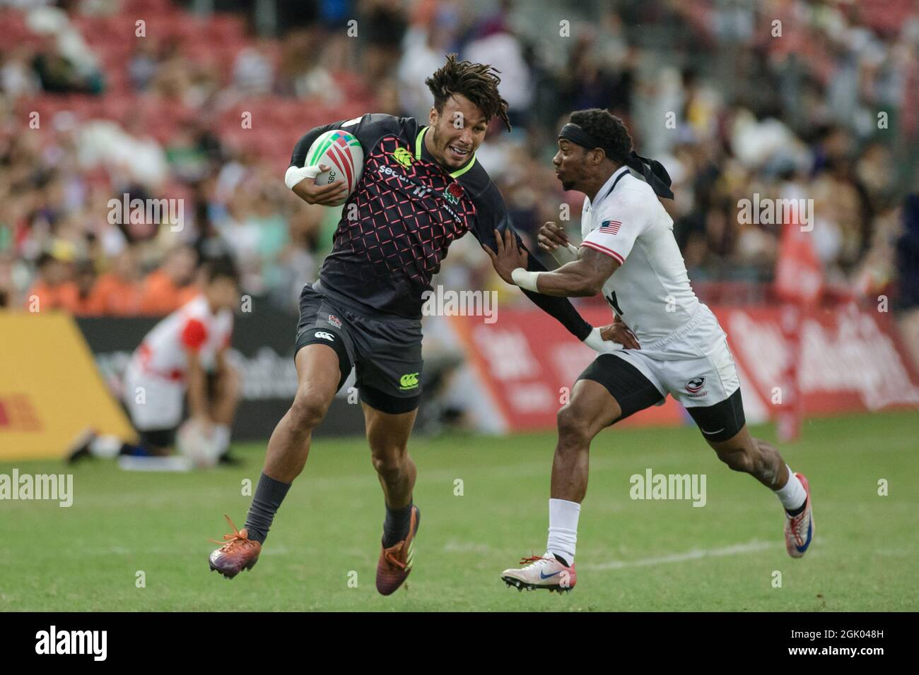 SINGAPORE-APRIL 14: Ryan Olowofela of England 7s Team (blue) in action against Carlin Isles of USA 7s team (white) during the Bronze medal match of HSBC World Rugby Singapore Sevens on April 14, 2019 at National Stadium in Singapore Stock Photo