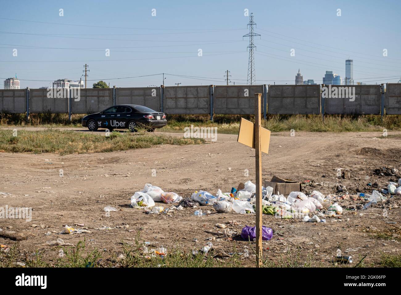 Garbage near the unpaved road in developing area of city- concept: ecology, environment and pollution; Nur-Sultan, Kazakhstan, Central Asia Stock Photo