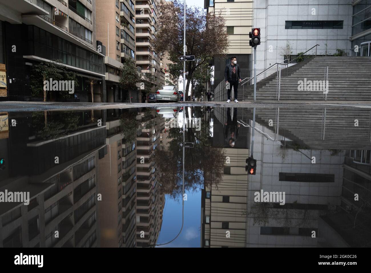 Santiago, Metropolitana, Chile. 12th Sep, 2021. A man with a face mask is reflected in a pool of water, after a rain at night in Santiago, Chile. (Credit Image: © Matias Basualdo/ZUMA Press Wire) Credit: ZUMA Press, Inc./Alamy Live News Stock Photo