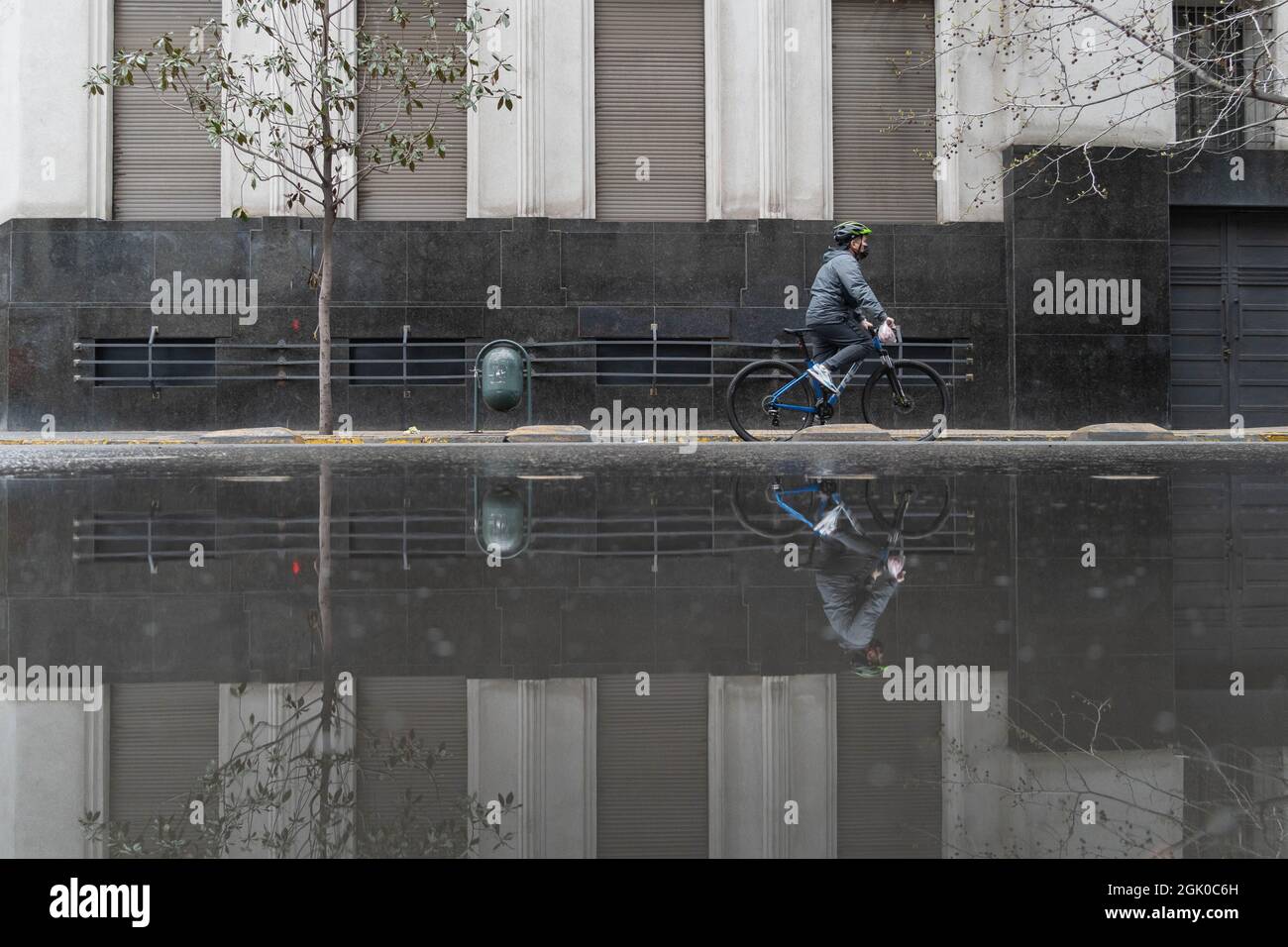 Santiago, Metropolitana, Chile. 12th Sep, 2021. A man on a bicycle is reflected in a pool of water, after a rain at night in Santiago, Chile. (Credit Image: © Matias Basualdo/ZUMA Press Wire) Credit: ZUMA Press, Inc./Alamy Live News Stock Photo
