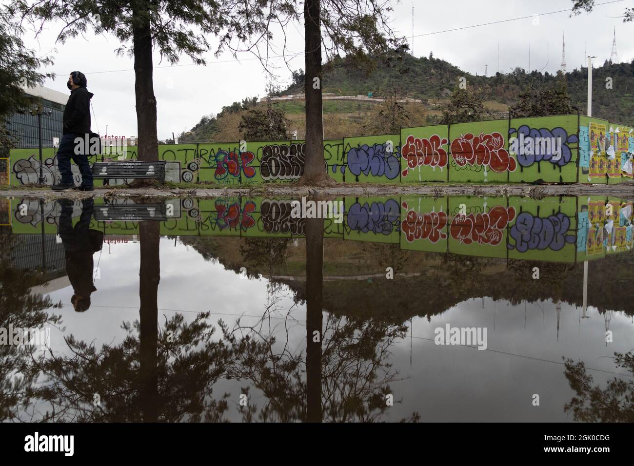 Santiago, Metropolitana, Chile. 12th Sep, 2021. A man with a mask is reflected in a pool of water, after a rain at night in Santiago, Chile. (Credit Image: © Matias Basualdo/ZUMA Press Wire) Credit: ZUMA Press, Inc./Alamy Live News Stock Photo