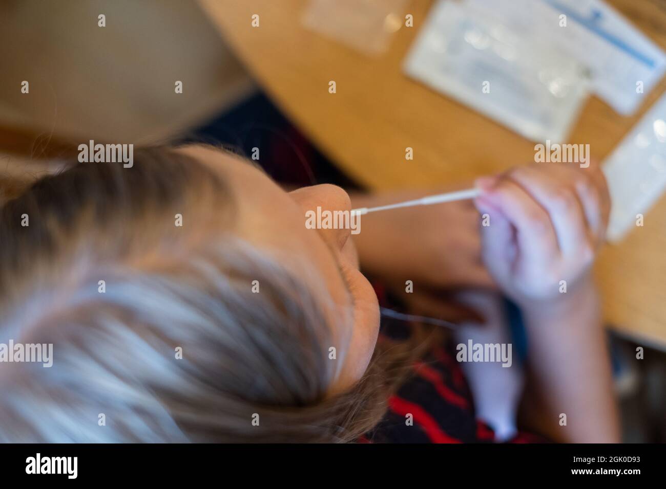 COVID-19 Ag Test kit for self-testing. Child testing herself for coronavirus at home. Stock Photo