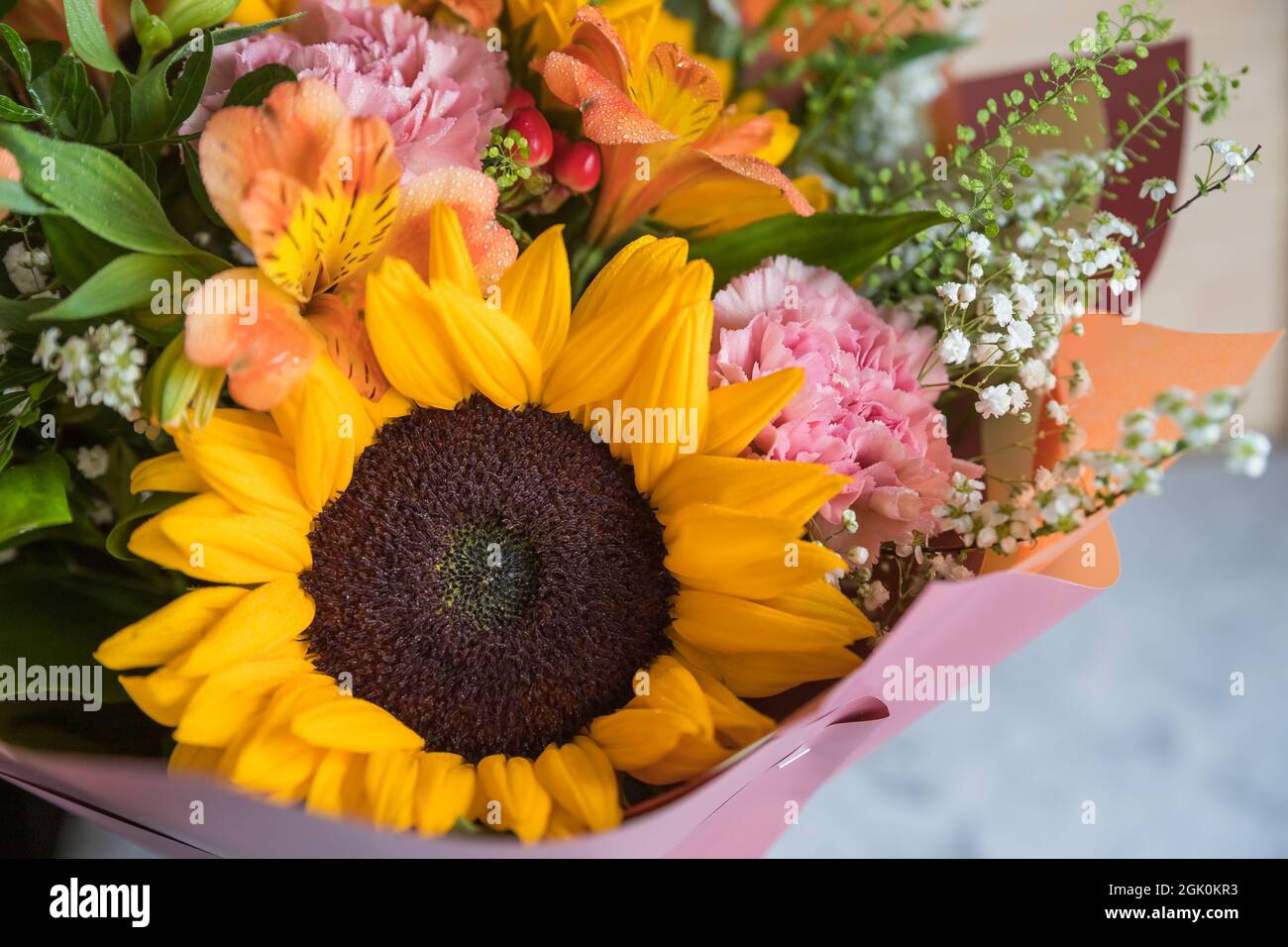 Fresh Bouquet of yellow sunflowers and pink carnations with white wood