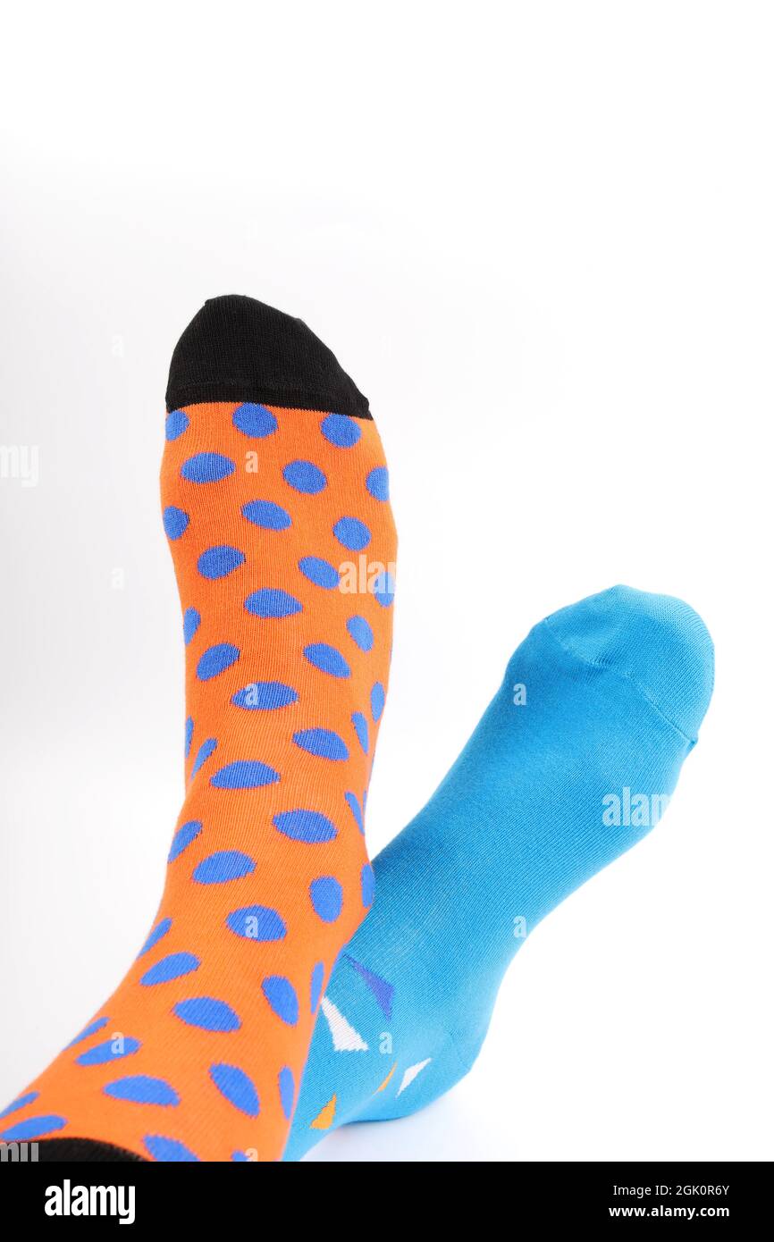 Legs with different a pair of mismatched socks on white background