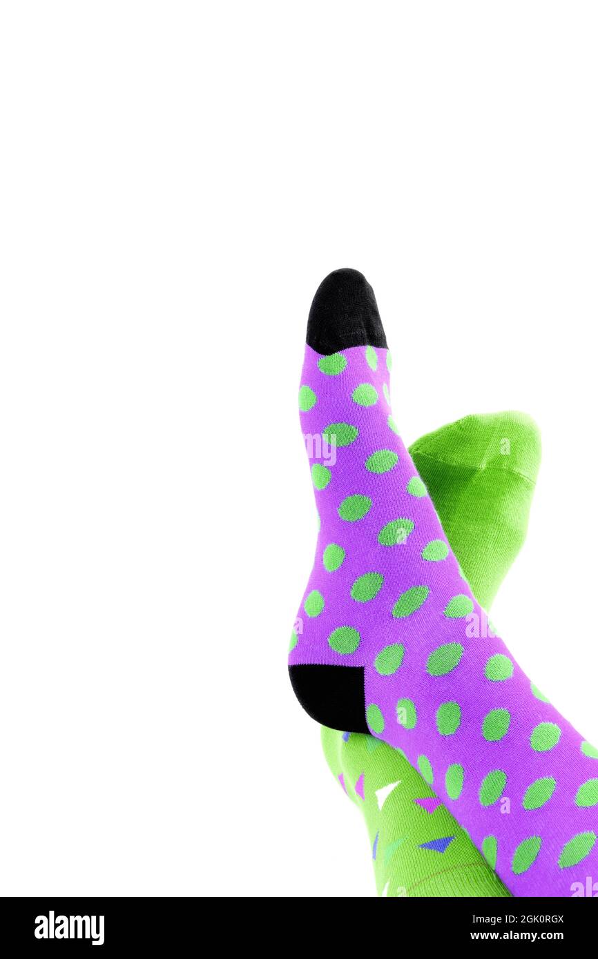 Legs with different a pair of mismatched socks on white background